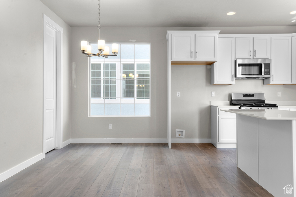 Kitchen with appliances with stainless steel finishes, a chandelier, light countertops, plenty of natural light, and recessed lighting