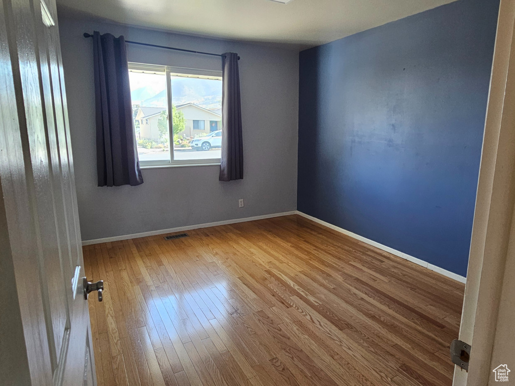 Unfurnished room with hardwood / wood-style flooring and baseboards
