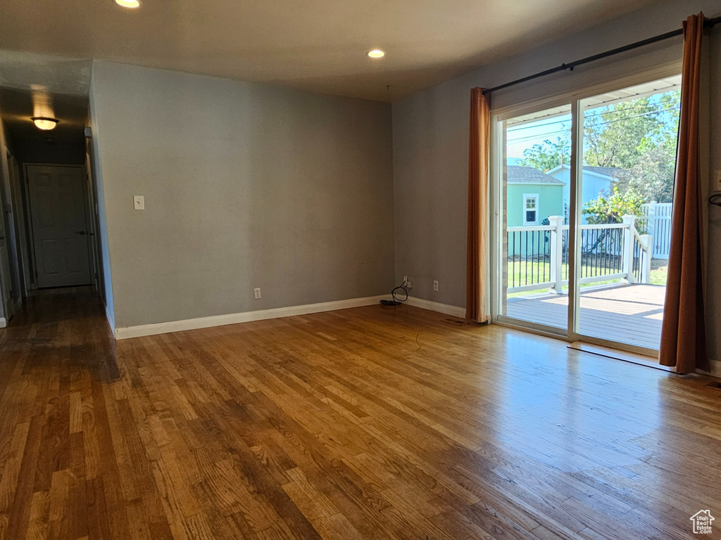 Empty room featuring healthy amount of natural light, wood finished floors, and recessed lighting