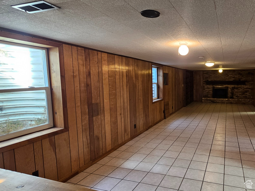 Hallway featuring wood walls and light tile patterned floors