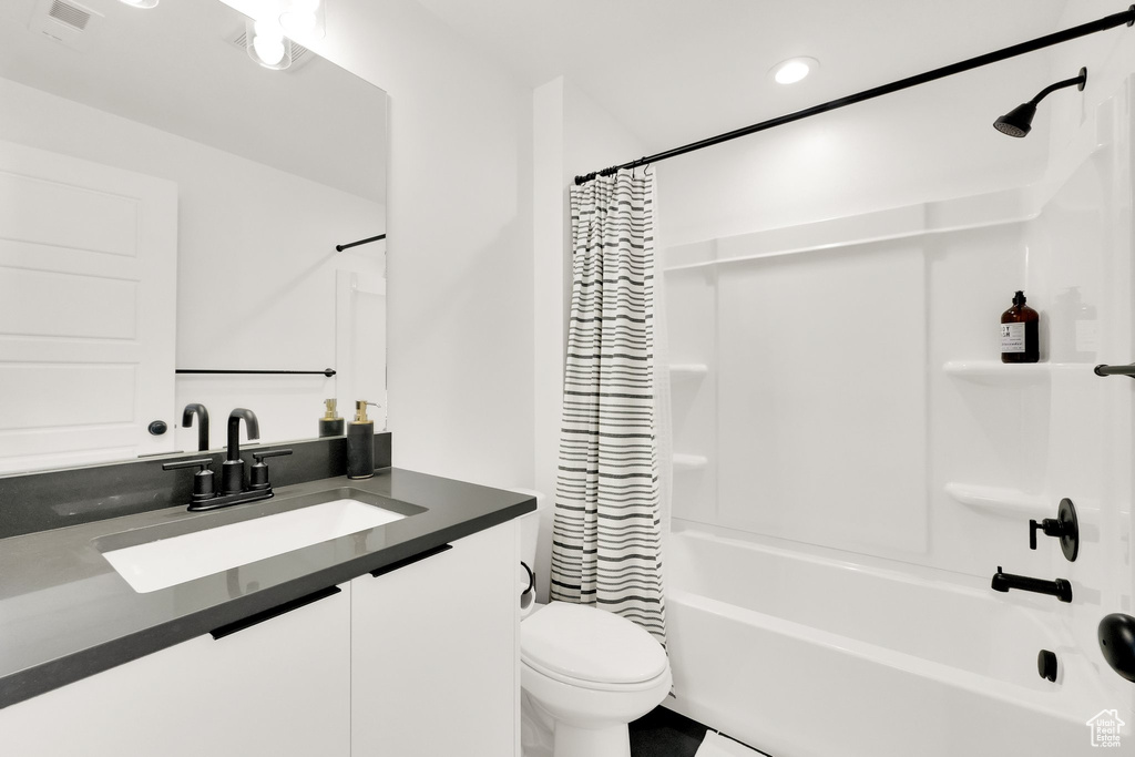 Full bathroom with vanity, toilet, shower / bathtub combination with curtain, recessed lighting, and visible vents