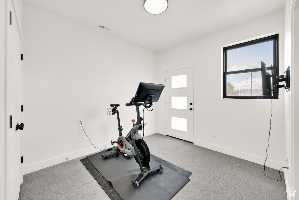 Exercise area featuring baseboards, visible vents, and carpet