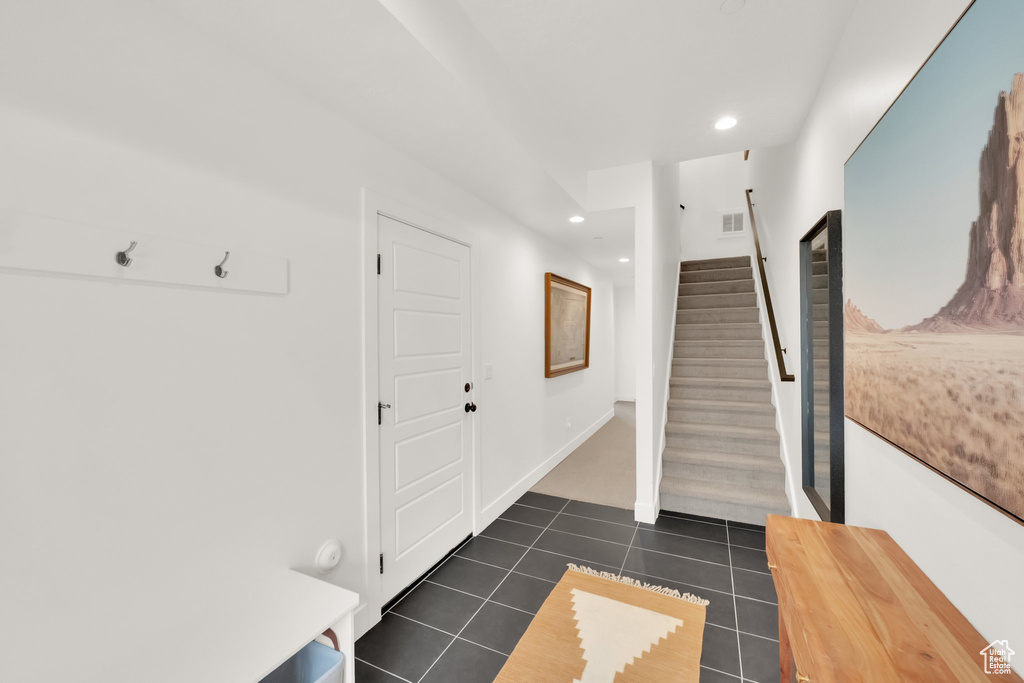 Interior space featuring dark tile patterned flooring, recessed lighting, and visible vents