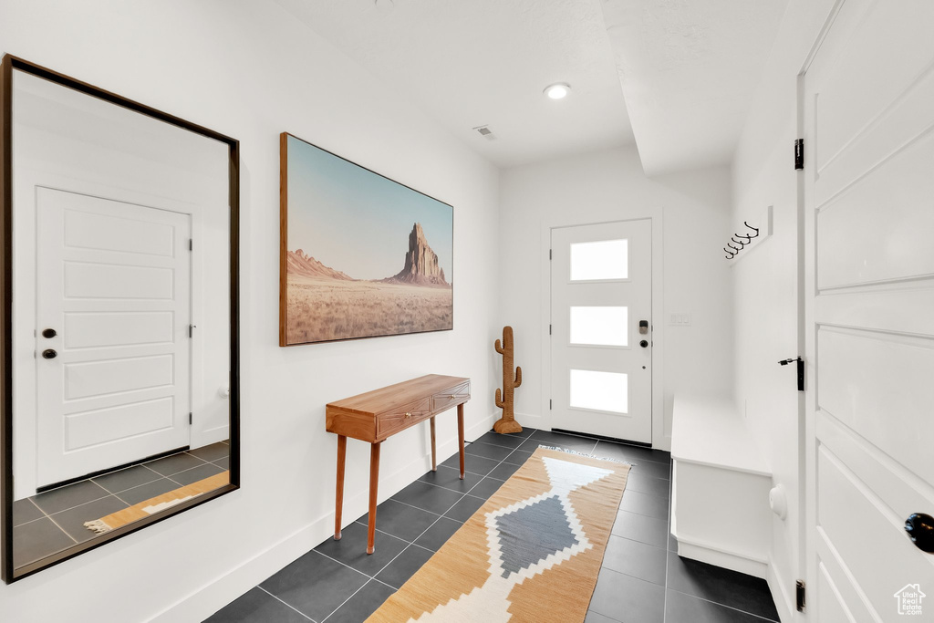 Foyer with baseboards, recessed lighting, and dark tile patterned flooring