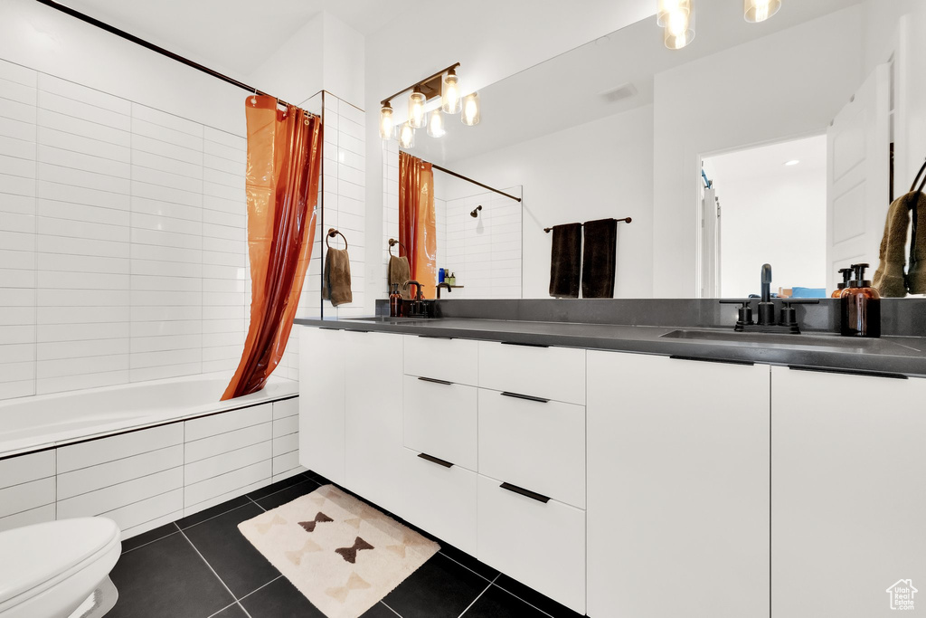 Full bath with tile patterned flooring, vanity, toilet, tiled shower / bath combo, and visible vents