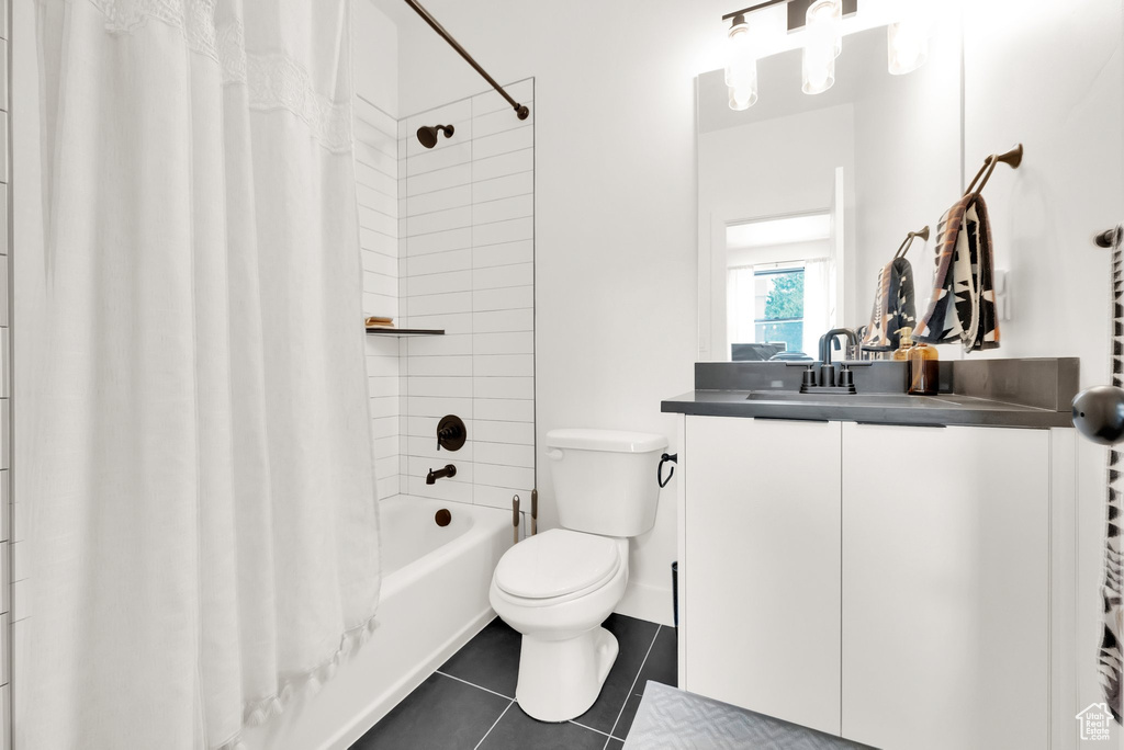 Bathroom with vanity, toilet, tile patterned floors, and shower / tub combo with curtain