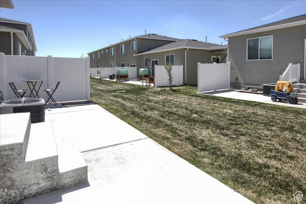 View of yard featuring a patio, fence, and cooling unit
