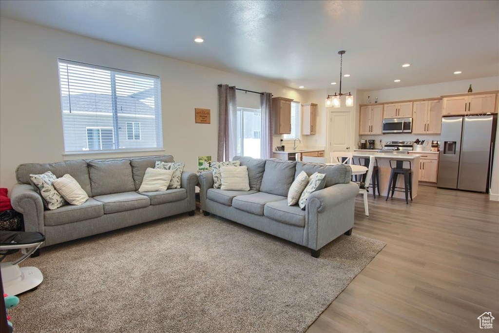Living area with light wood-type flooring and recessed lighting