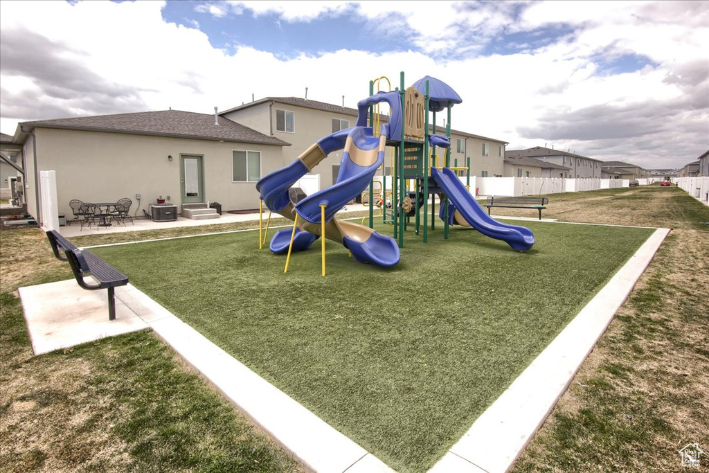 Community play area featuring fence, a yard, and entry steps
