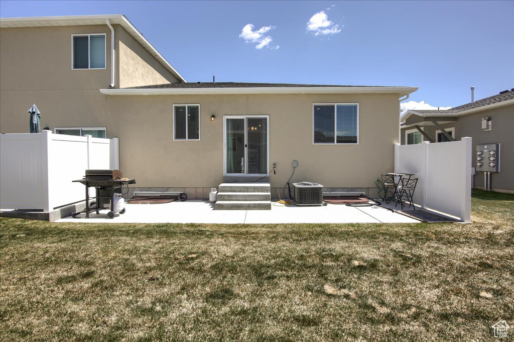 Back of house featuring fence, a lawn, and a patio area