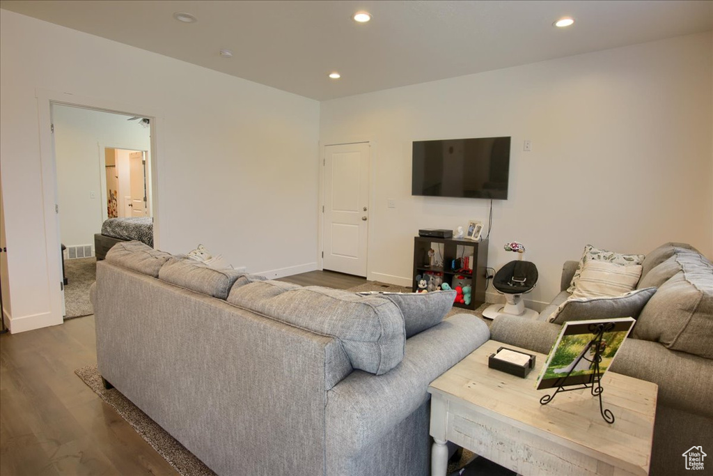 Living room featuring recessed lighting, dark wood-style flooring, baseboards, and visible vents