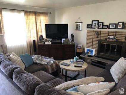 Carpeted living room with a brick fireplace