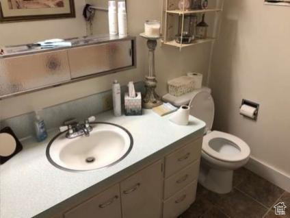 Bathroom with vanity, baseboards, tile patterned floors, and toilet