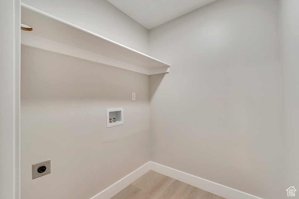 Washroom with laundry area, baseboards, hookup for a washing machine, light wood-style flooring, and hookup for an electric dryer