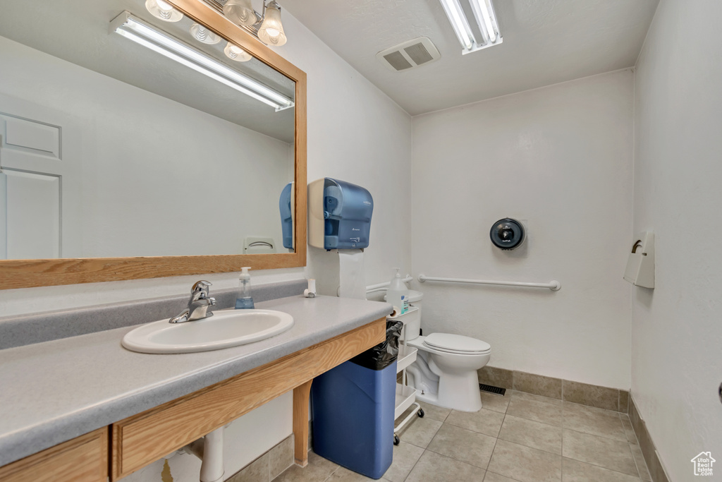 Bathroom with visible vents, toilet, baseboards, tile patterned floors, and a sink