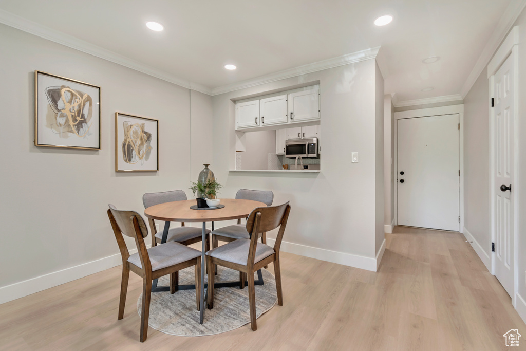 Dining area featuring recessed lighting, baseboards, ornamental molding, and light wood-type flooring
