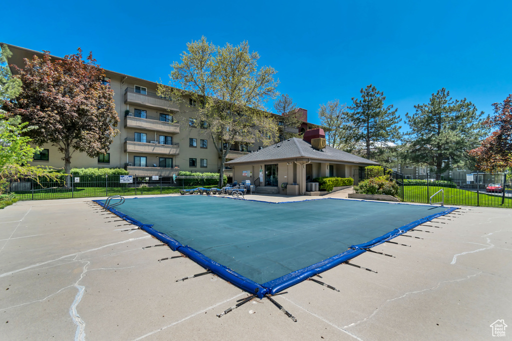 Community pool featuring fence and a patio