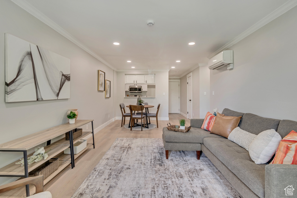 Living area featuring crown molding, light wood-style floors, recessed lighting, and a wall mounted air conditioner