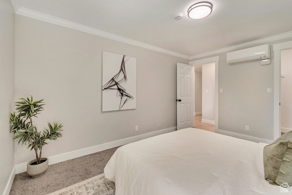 Bedroom with baseboards, a wall mounted AC, ornamental molding, and carpet