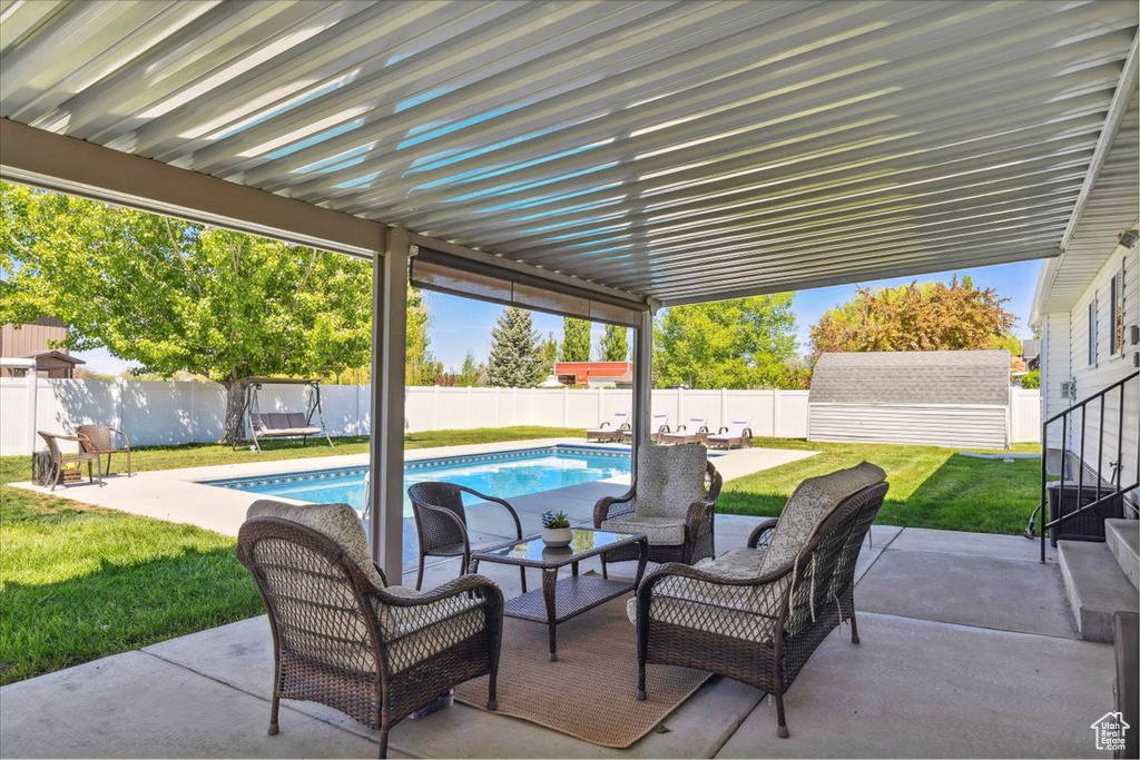 View of patio with a fenced in pool, a fenced backyard, an outdoor living space, and an outdoor structure