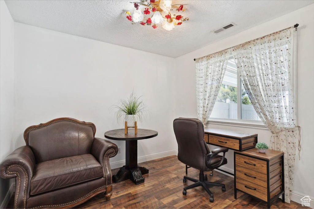 Home office with baseboards, a textured ceiling, and wood finished floors