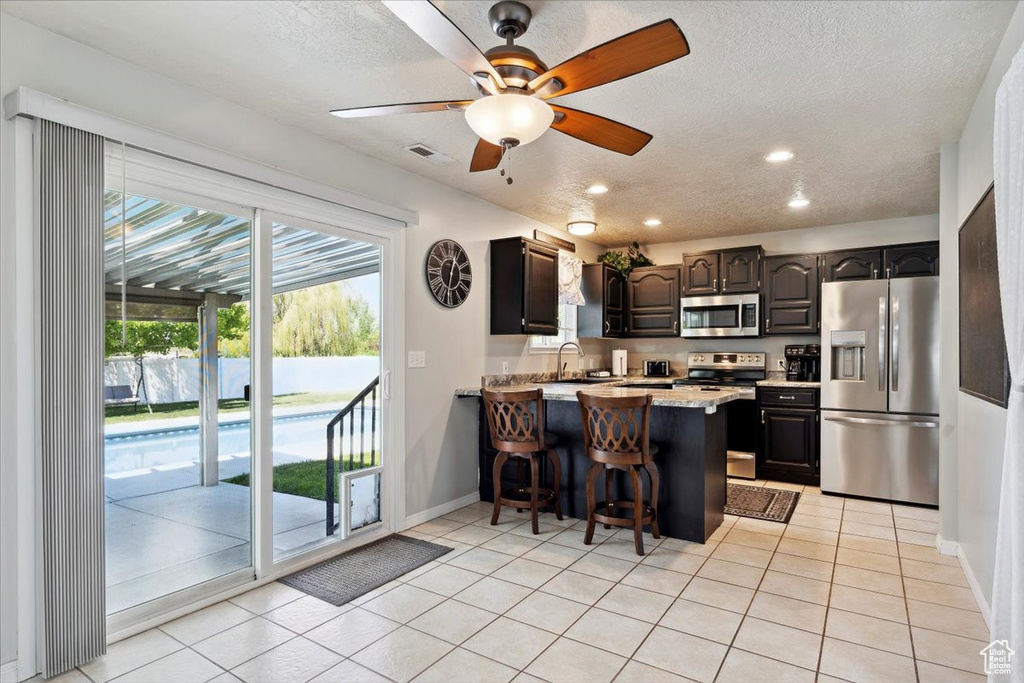 Kitchen with visible vents, a peninsula, baseboards, ceiling fan, and appliances with stainless steel finishes