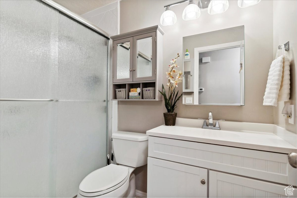 Full bathroom featuring an enclosed shower, toilet, and vanity