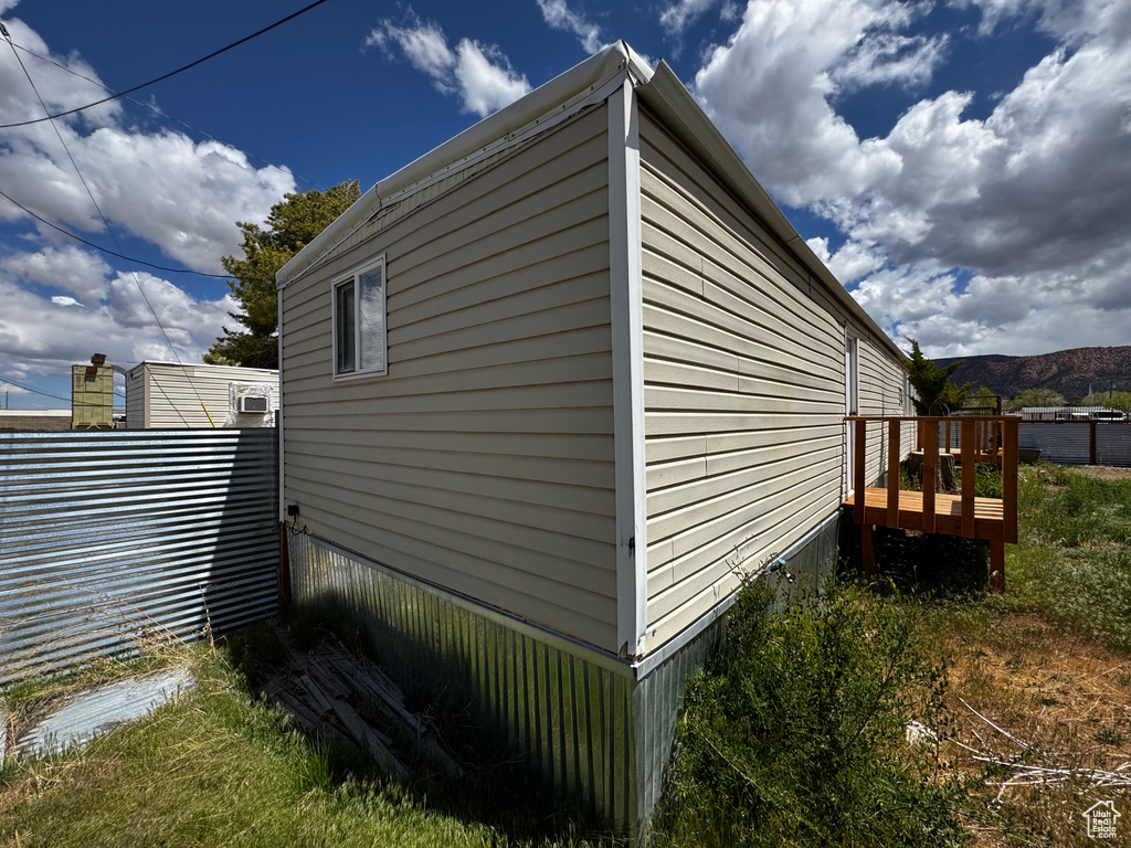 View of side of home with a wooden deck