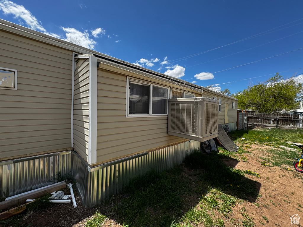 View of side of home featuring central air condition unit and fence