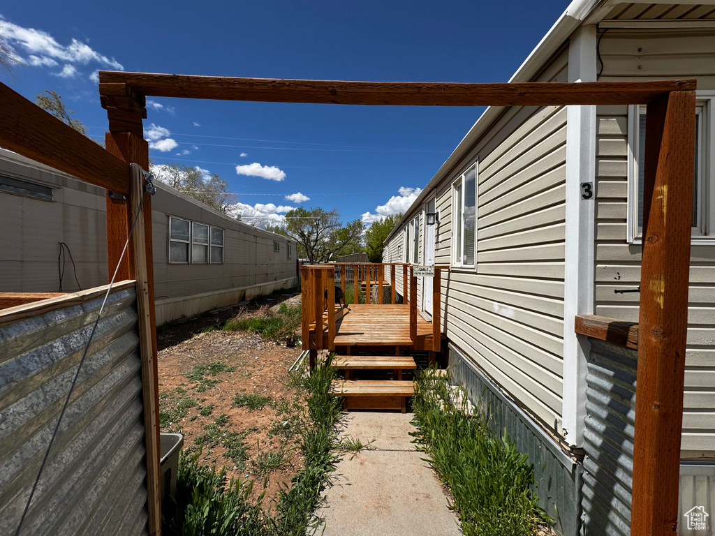View of side of property with a wooden deck