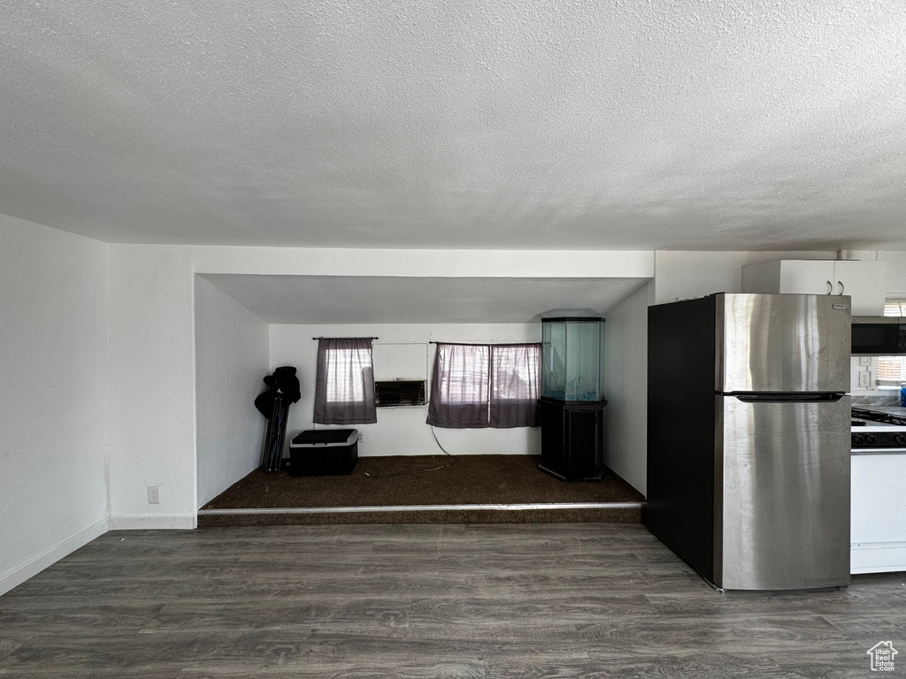 Unfurnished living room featuring a textured ceiling and wood finished floors