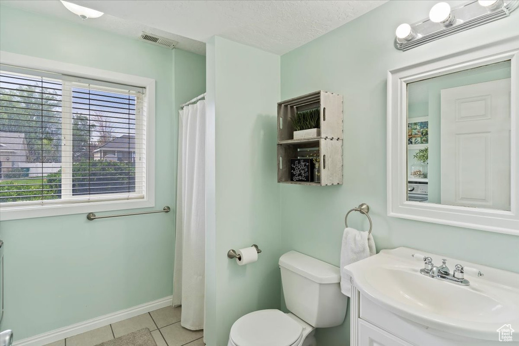 Bathroom featuring vanity, toilet, tile patterned floors, baseboards, and visible vents