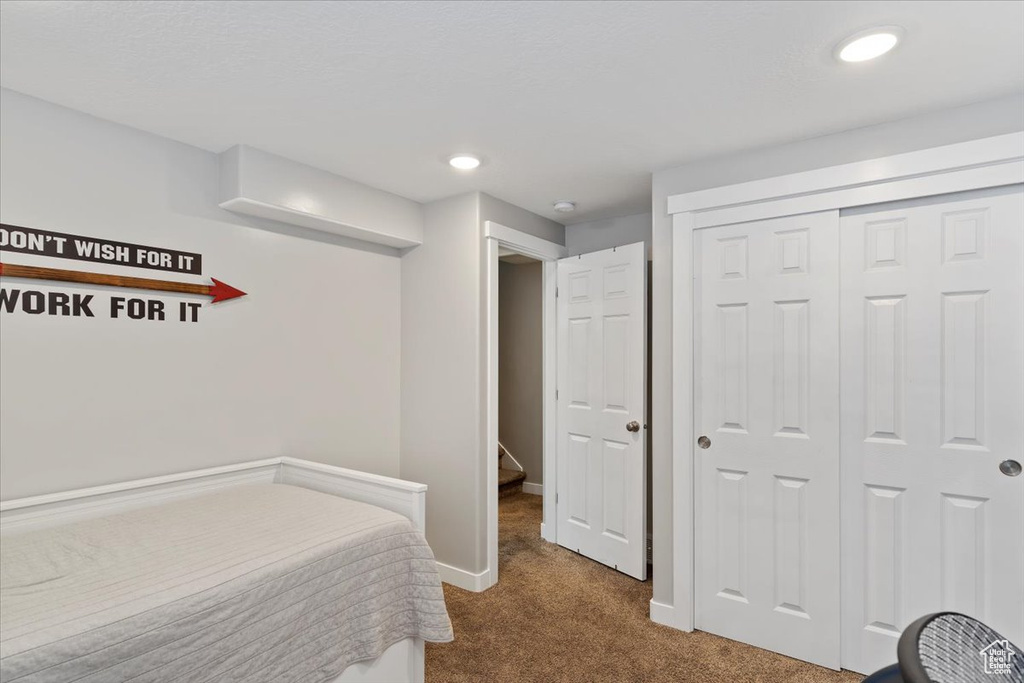 Carpeted bedroom with baseboards, recessed lighting, and a closet