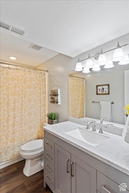 Bathroom with visible vents, wood finished floors, toilet, and vanity