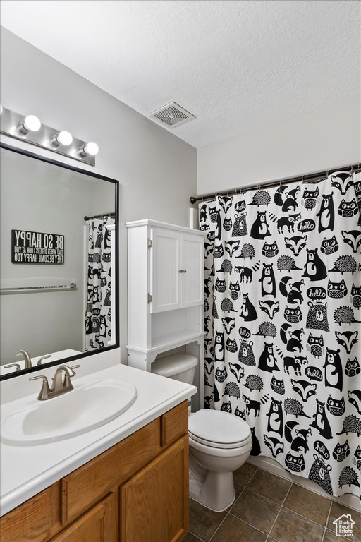 Full bath featuring a textured ceiling, visible vents, tile patterned flooring, vanity, and toilet