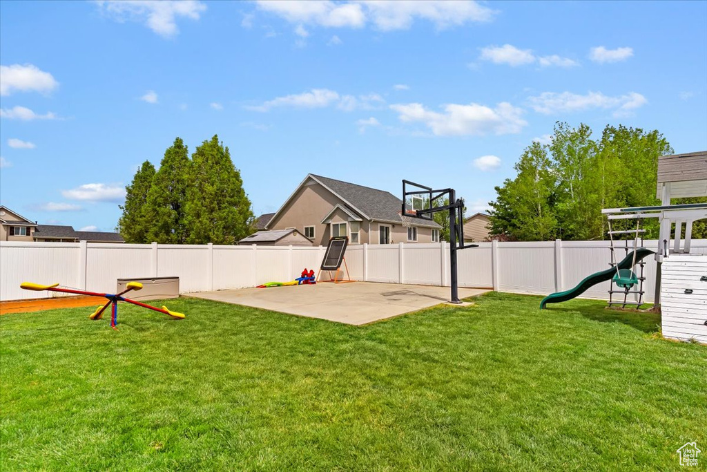 View of yard featuring a playground, a fenced backyard, and a patio area