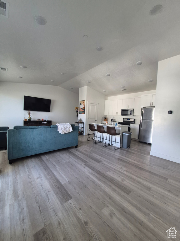 Living area with baseboards, visible vents, and wood finished floors
