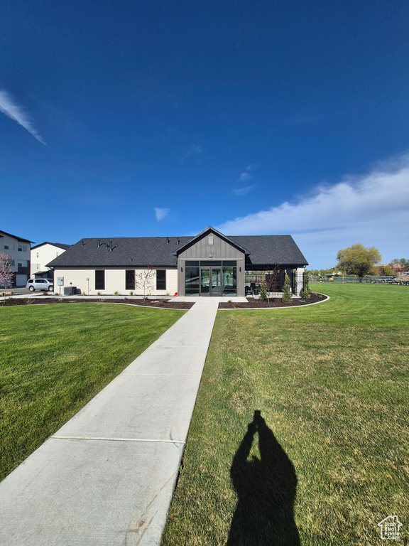 View of front of house featuring roof with shingles and a front lawn