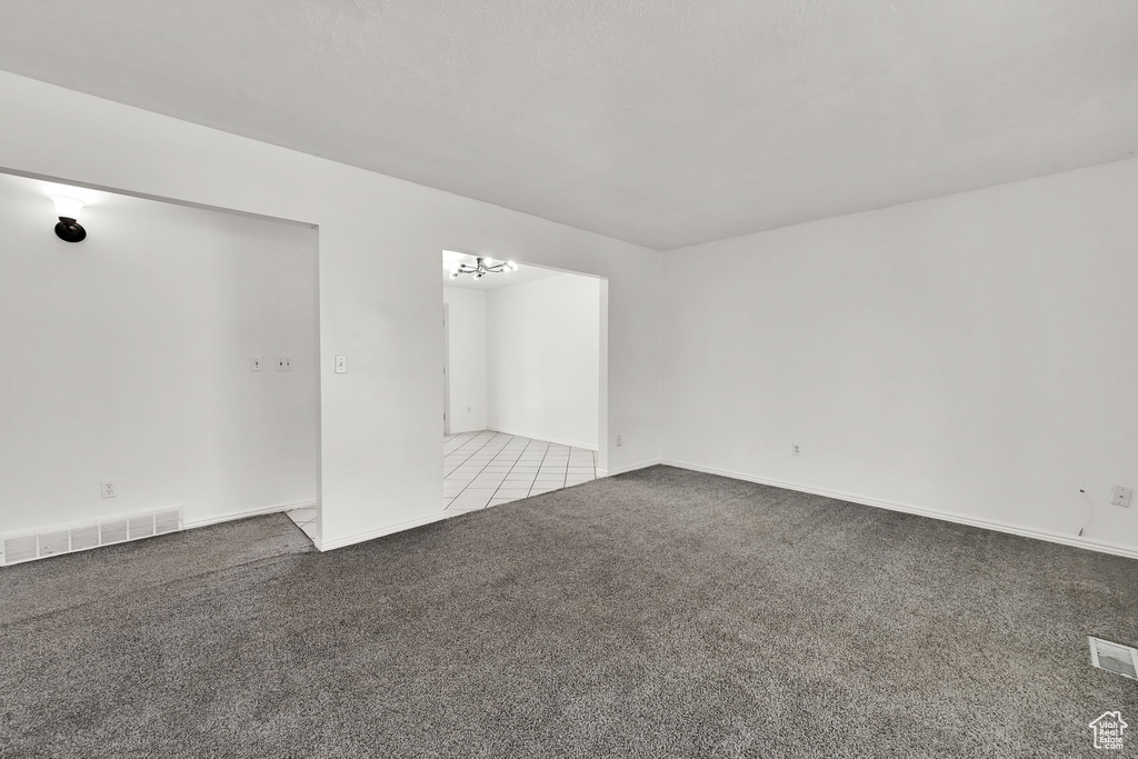 Empty room featuring baseboards, carpet, and visible vents
