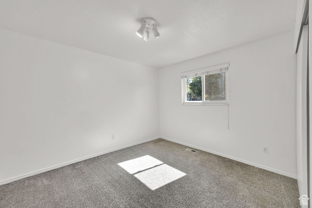 Unfurnished room featuring carpet floors, baseboards, and visible vents