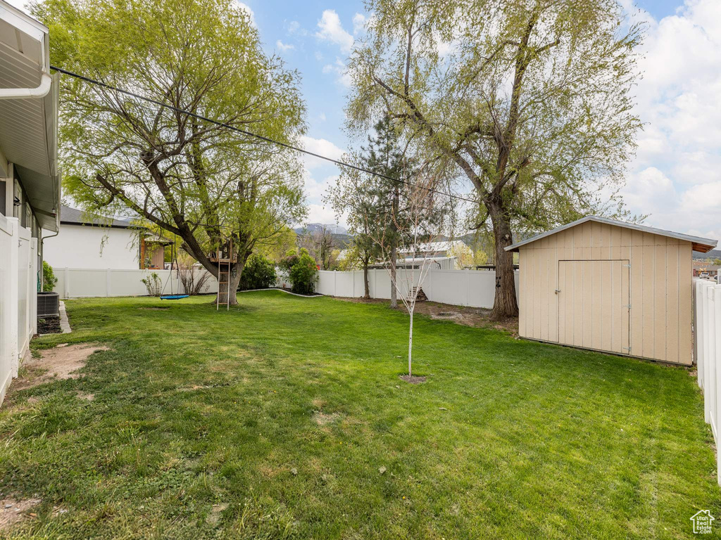 View of yard featuring an outbuilding, a shed, and a fenced backyard
