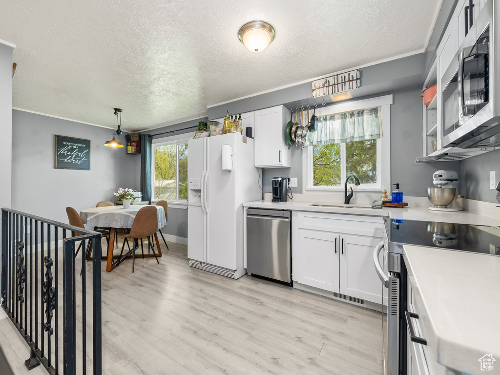 Kitchen with visible vents, a sink, a textured ceiling, and appliances with stainless steel finishes
