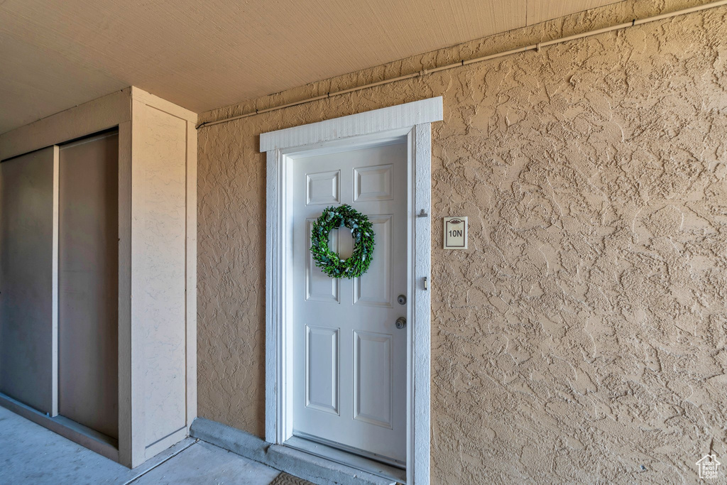 Doorway to property featuring stucco siding