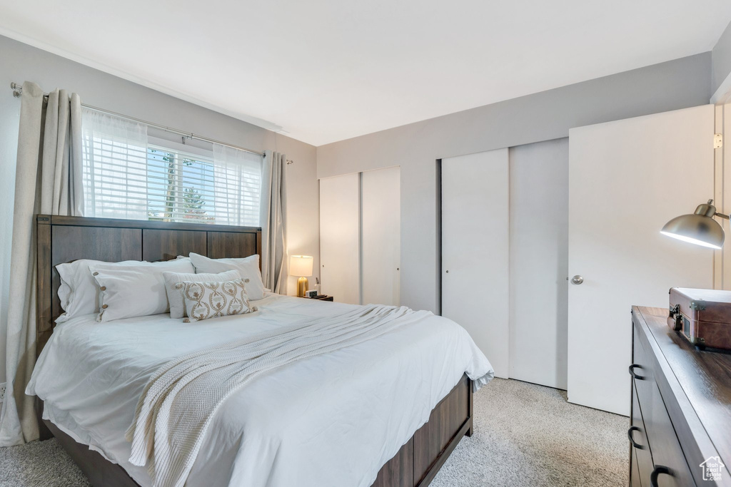 Bedroom with multiple closets and light carpet