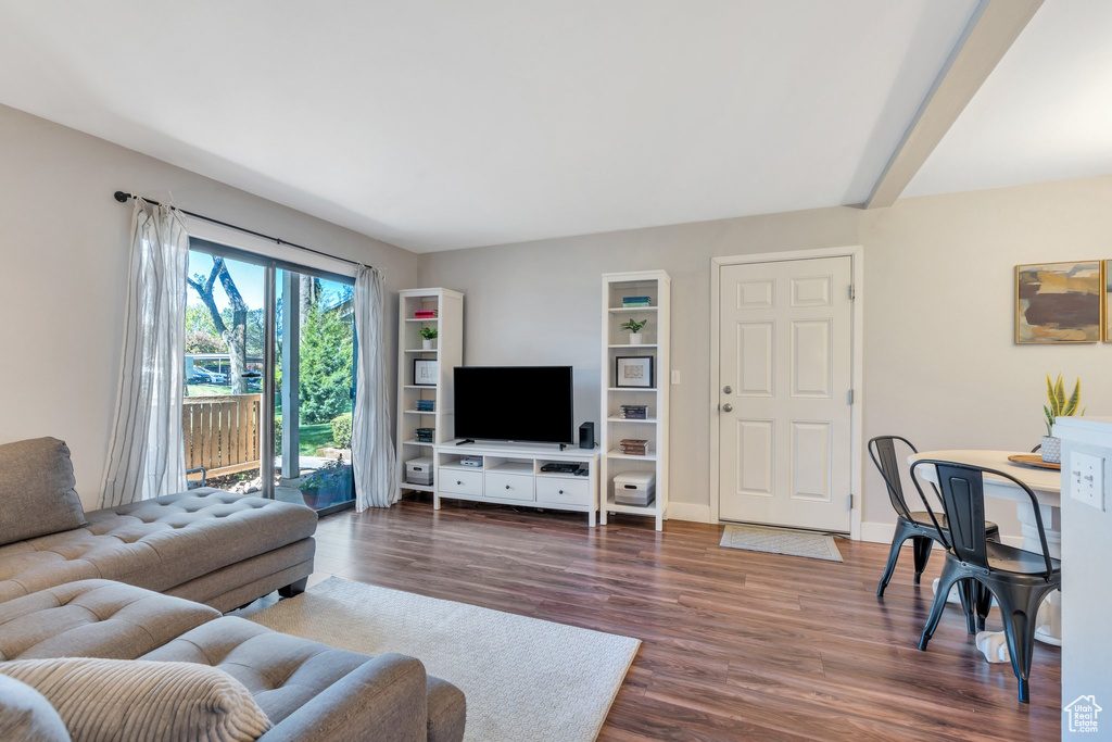 Living area featuring baseboards and dark wood-style floors