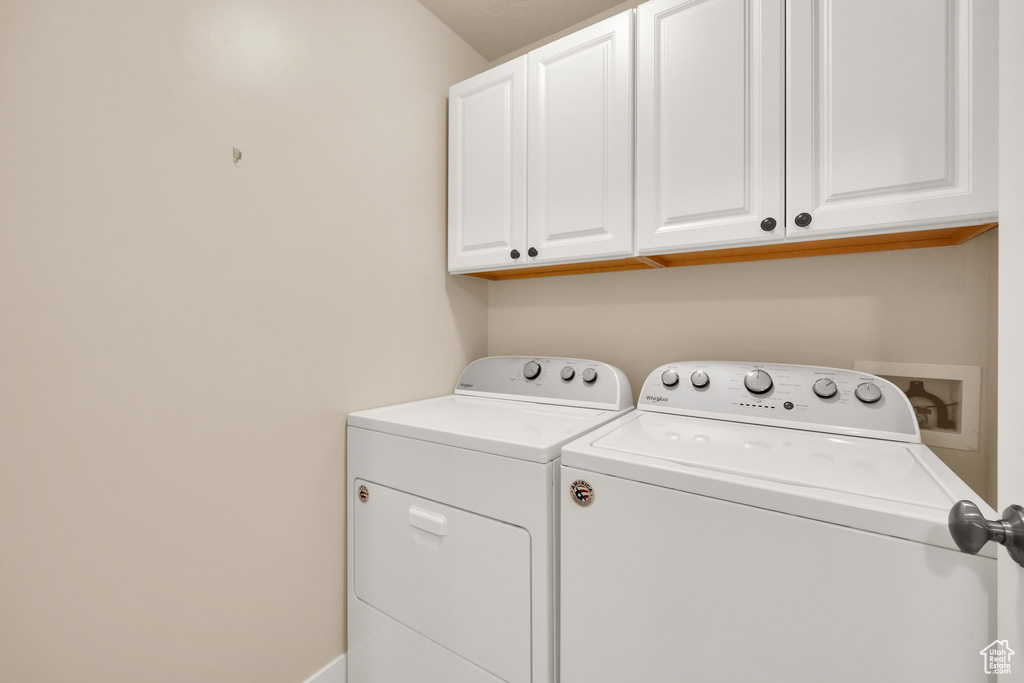Laundry area featuring cabinet space and washer and clothes dryer