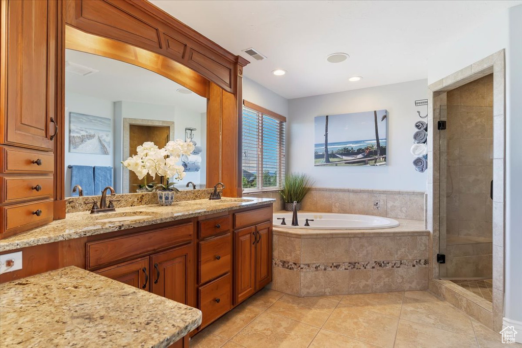Full bath with tile patterned flooring, visible vents, a sink, and a garden tub