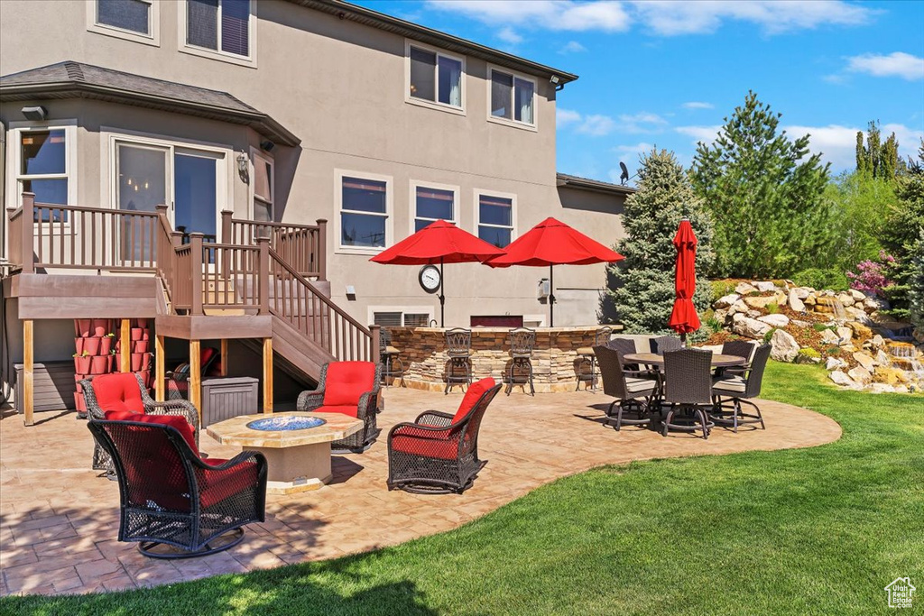 View of patio featuring stairway, a deck, a fire pit, and area for grilling