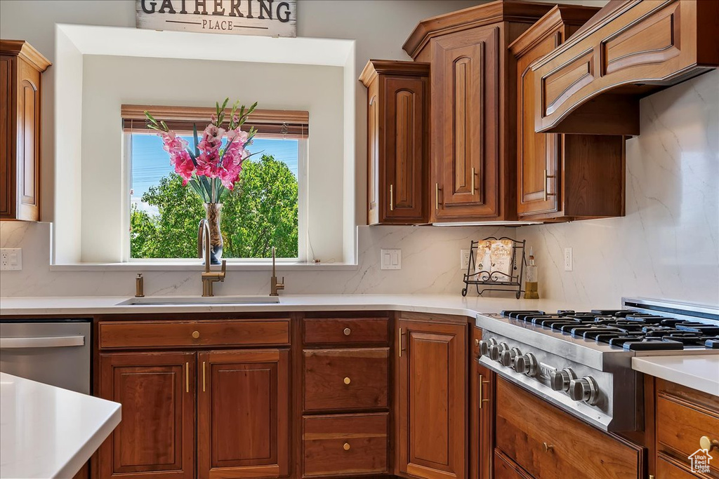 Kitchen with a sink, light countertops, and stainless steel appliances