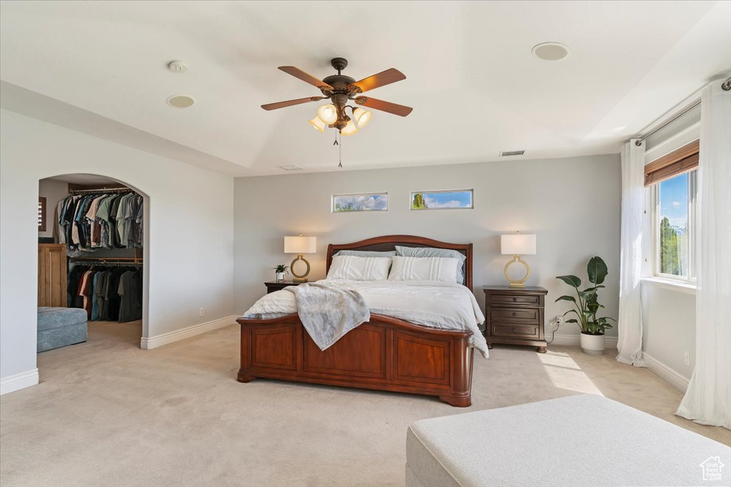 Bedroom with baseboards, visible vents, a ceiling fan, and light colored carpet